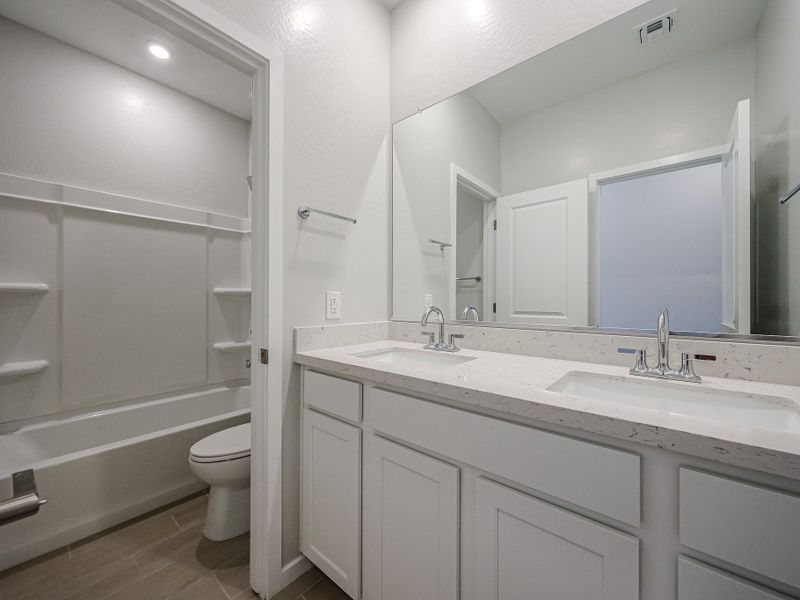 A bathroom with a tub sink and toilet.