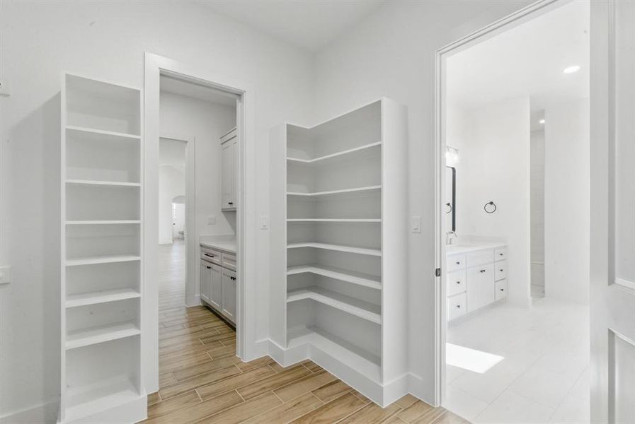 Walk in closet with wood finish floors Walk in closet with wood finish floors