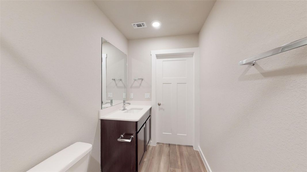 A well-appointed bath features a modern vanity, a large mirror, and durable flooring. A well-appointed bath features a modern vanity, a large mirror, and durable flooring.