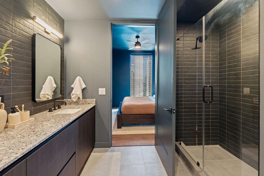 Representative Photo. Primary Bath with spacious double vanity, floor to ceiling tile, and a walk in shower