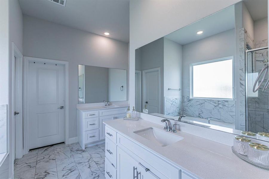 Bathroom with two vanities, light marble finish flooring, a garden tub, and a marble finish shower Bathroom with two vanities, light marble finish flooring, a garden tub, and a marble finish shower