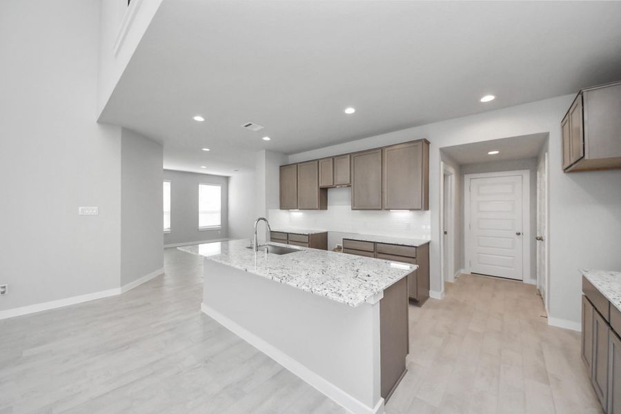 Discover another perspective of this stunning kitchen, generously appointed with an abundance of counter space! Sample photo of completed home with similar floor plan. Actual colors and selections may vary.