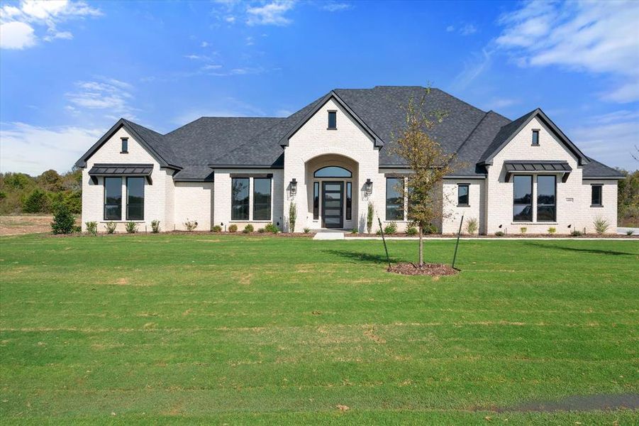 French country inspired facade featuring a front yard