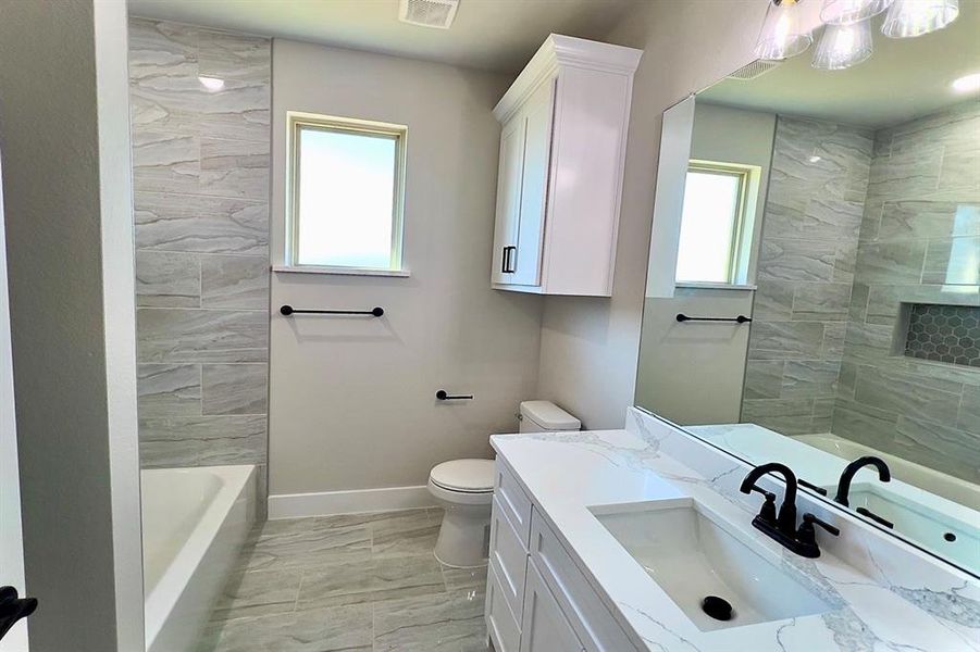 Full bath featuring vanity, light marble finish flooring, and shower / bathtub combination