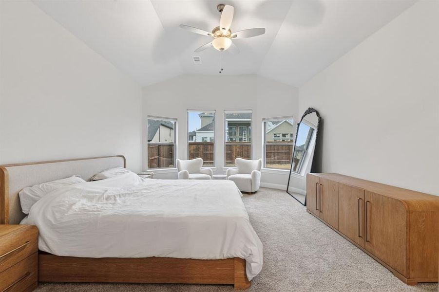 Bedroom with light carpet, ceiling fan, and vaulted ceiling Bedroom with light carpet, ceiling fan, and vaulted ceiling