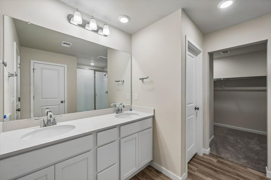A bathroom with a sink and a shower unit.