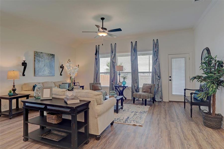 Living room with crown molding, hardwood / wood-style flooring, and ceiling fan