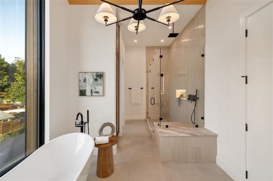 Spacious bathroom featuring a freestanding soaking tub, a large glass-enclosed shower with a built-in bench, contemporary matte black fixtures, and a prominent window Spacious bathroom featuring a freestanding soaking tub, a large glass-enclosed shower with a built-in bench, contemporary matte black fixtures, and a prominent window