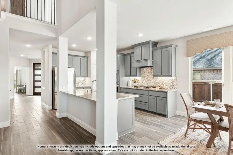 Open-concept kitchen with gray cabinets, tile backsplash, and dining area on wood-look floors with upper loft railing visible above Open-concept kitchen with gray cabinets, tile backsplash, and dining area on wood-look floors with upper loft railing visible above