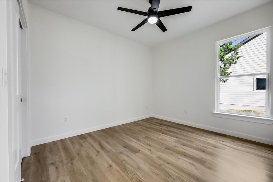 Empty room with light wood-type flooring and a ceiling fan Empty room with light wood-type flooring and a ceiling fan