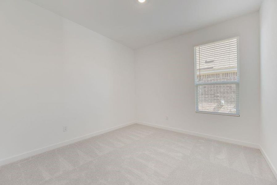Spare room with light carpet and baseboards Spare room with light carpet and baseboards