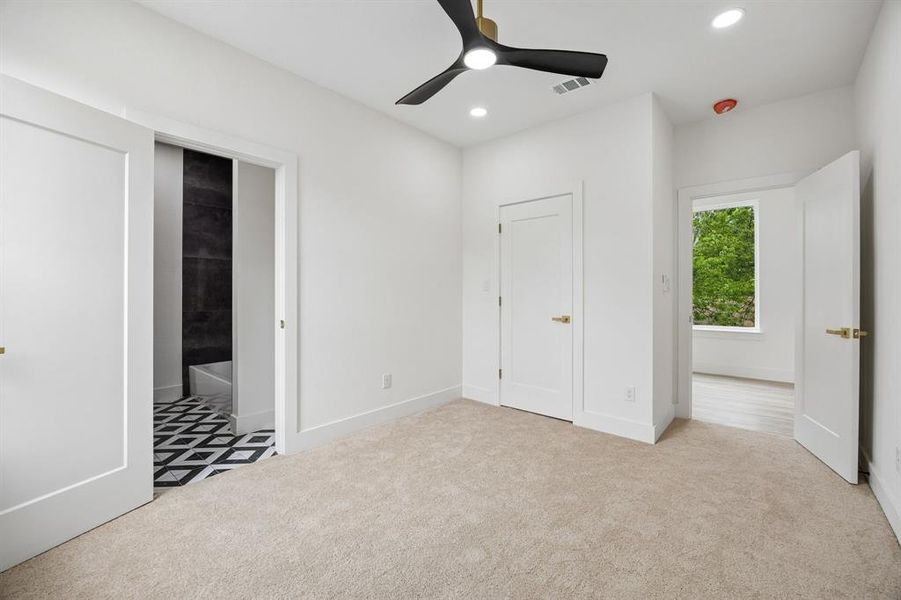 Plush carpeting throughout, featuring a modern ceiling fan with integrated lighting, recessed ceiling lights, and two panel doors with gold-finish hardware Plush carpeting throughout, featuring a modern ceiling fan with integrated lighting, recessed ceiling lights, and two panel doors with gold-finish hardware