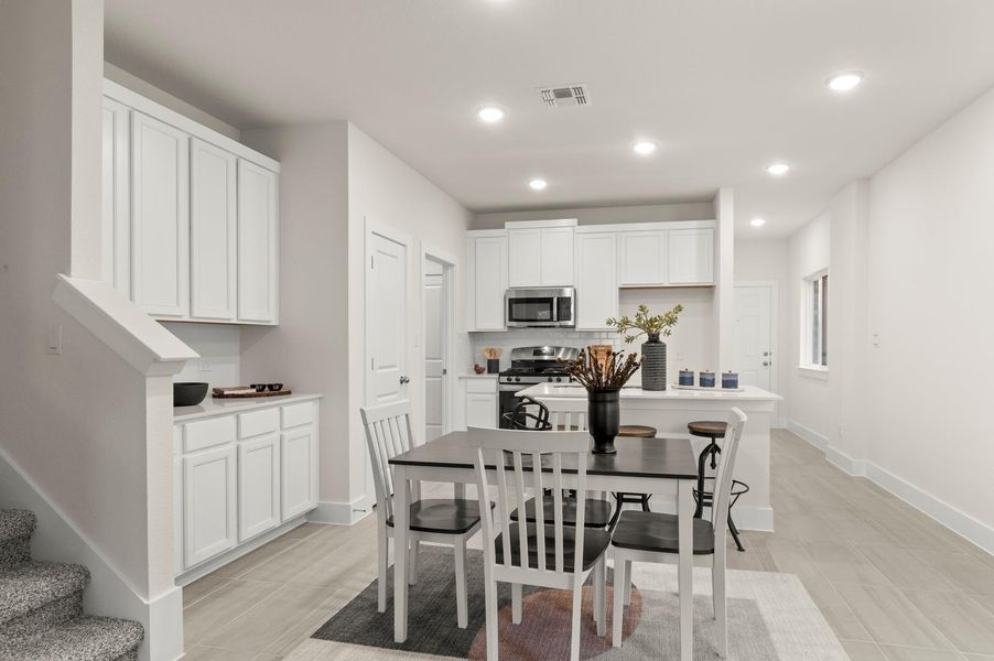A streamlined open-concept layout connects the bright dining area to a modern kitchen.