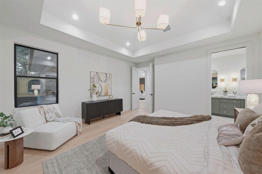 Spacious primary bedroom provides room for a sitting area while maintaining a serene, comfortable feel.