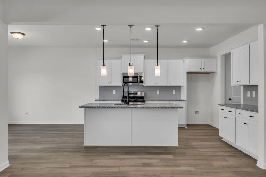 Large kitchen island with a separate dining area to the left.