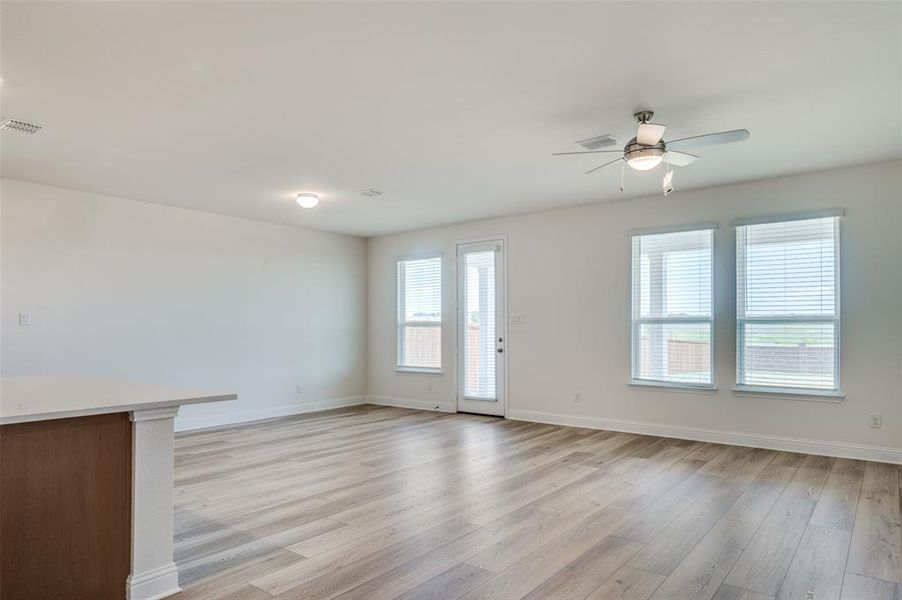Unfurnished living room featuring a ceiling fan and light wood-style flooring