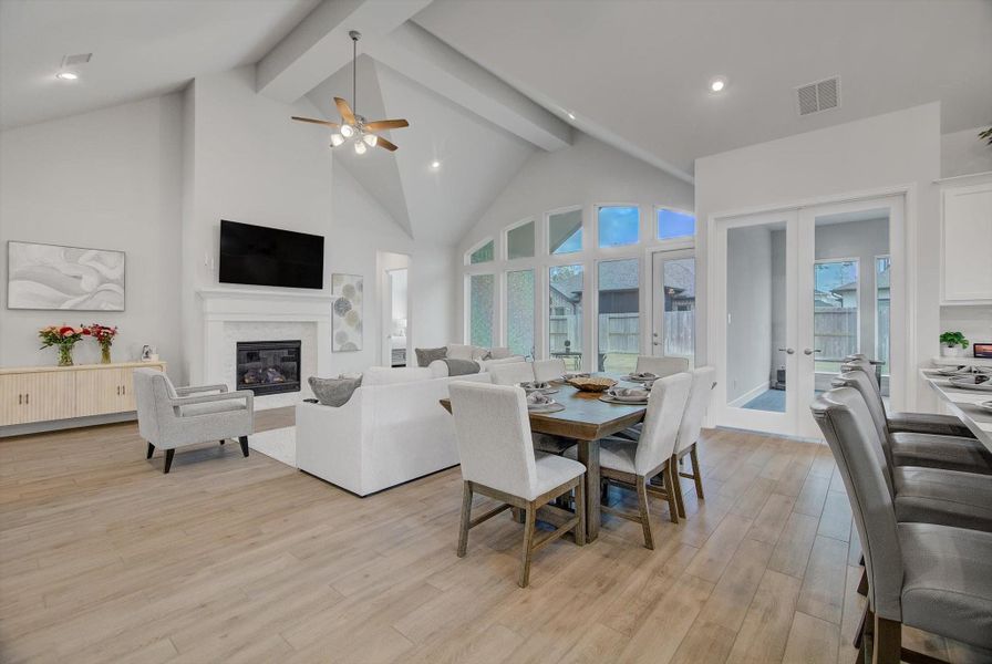 The living room features a beautiful gas-log fireplace as its focal point, paired with a wall of windows that fills the space with natural light and offers a seamless view and easy access to the back patio.