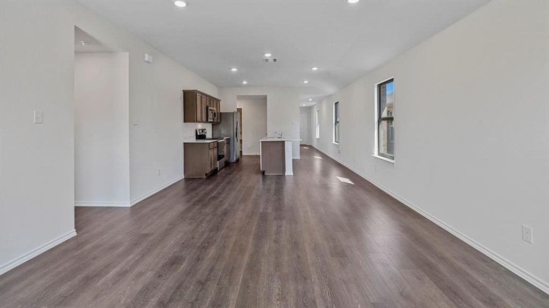 Unfurnished living room with recessed lighting and dark wood-style floors Unfurnished living room with recessed lighting and dark wood-style floors