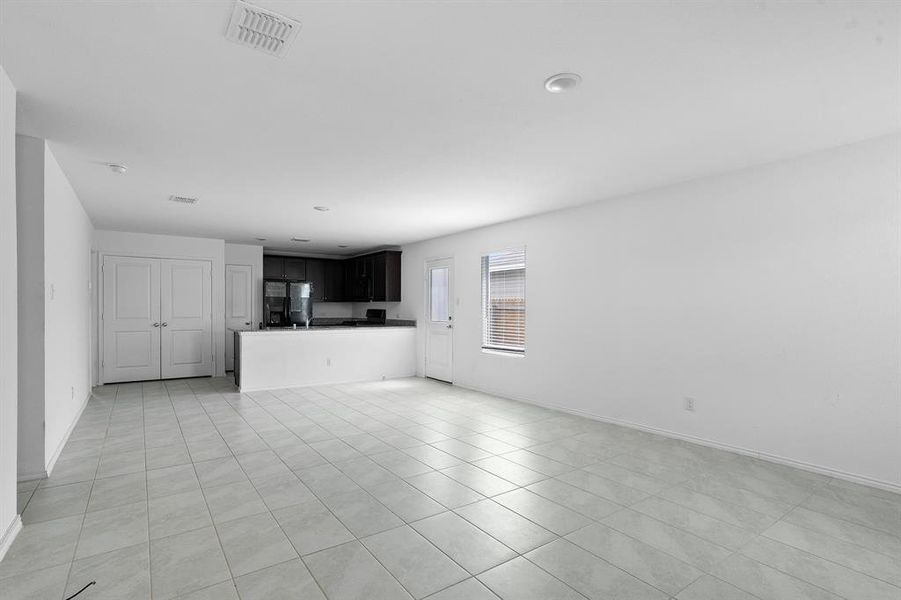 Unfurnished living room with baseboards and light tile patterned flooring