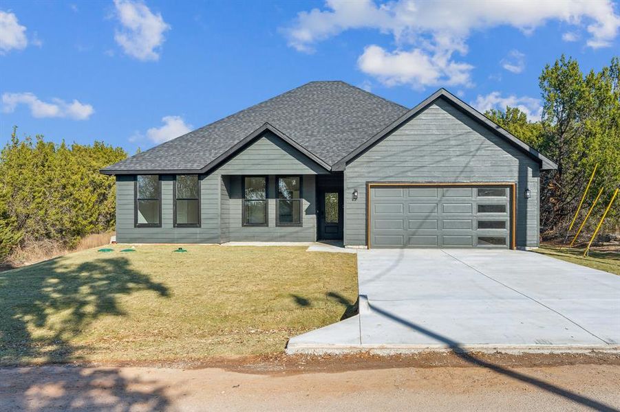 View of front of property featuring a front yard and a garage