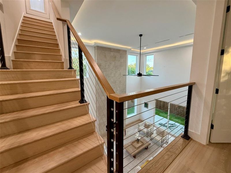 Stairway with plenty of natural light, wood finished floors, recessed lighting, and ceiling fan
