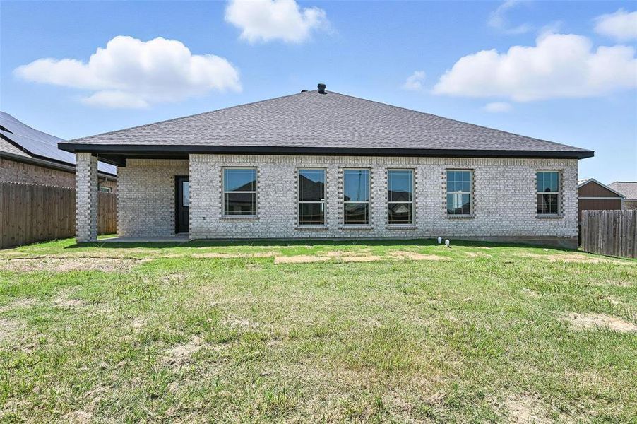 Rear view of property featuring roof with shingles, a fenced backyard, and brick siding Rear view of property featuring roof with shingles, a fenced backyard, and brick siding