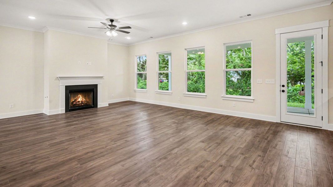 Gathering room with fireplace, ceiling fan, and hard surface flooring Gathering room with fireplace, ceiling fan, and hard surface flooring