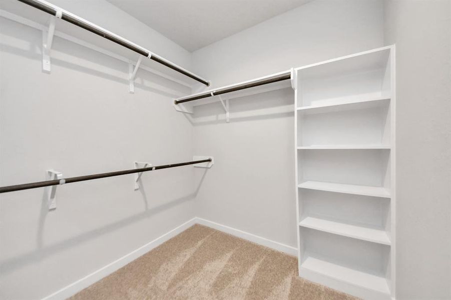 Walk-in closet that epitomizes luxury and practicality. This generously sized space features built-in shelving, offering abundant room for impeccable organization. High ceilings and recessed lighting create a bright and welcoming ambiance.