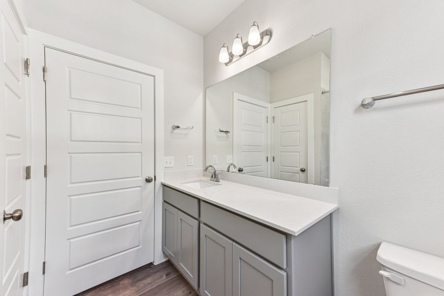 A bathroom with white cabinets.