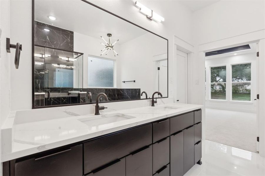 Bathroom with vanity, an inviting chandelier, and a shower with door