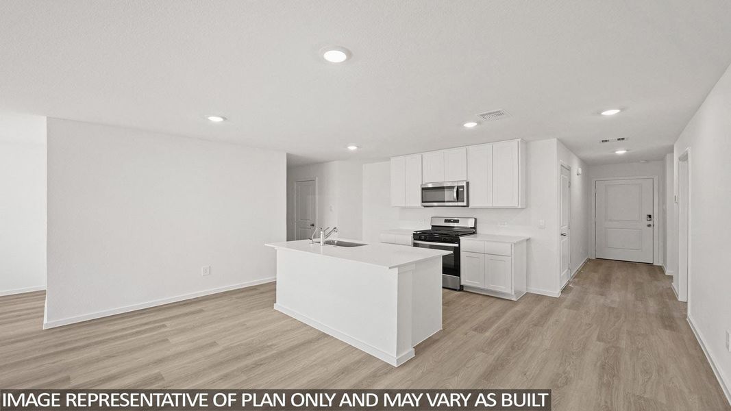 Kitchen featuring stainless steel appliances, light wood finished floors, white cabinets, recessed lighting, and an island with sink
