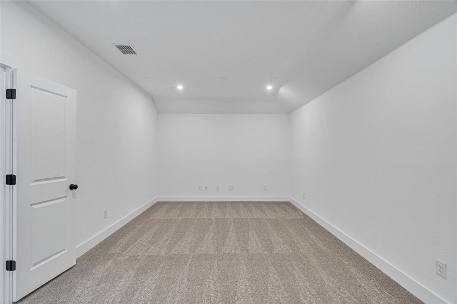 An adaptable living space with clean lines, neutral carpet, and recessed lighting awaits your personal touch.