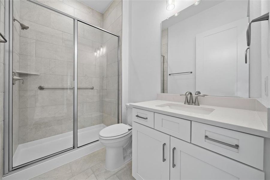 Bathroom with a glass-enclosed shower featuring light-toned tile, a built-in shower niche, and a brushed nickel shower head