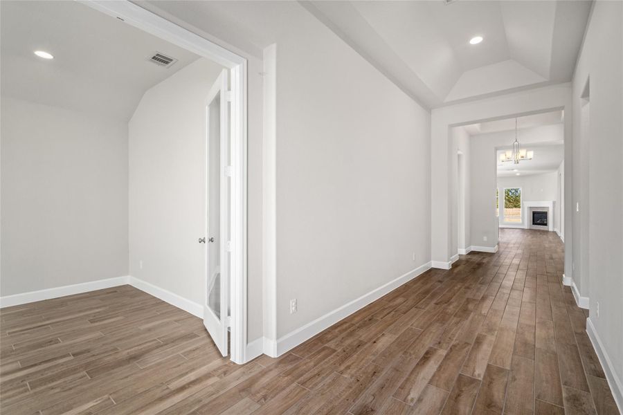 Hallway perspective leading into the main living areas and offering a glimpse of the dedicated office.