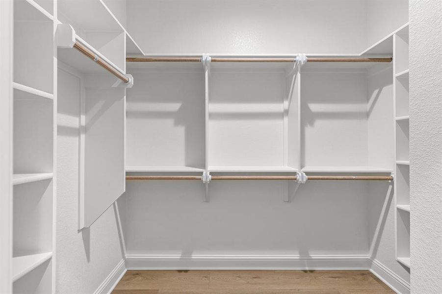 Walk in closet featuring light wood-style flooring Walk in closet featuring light wood-style flooring
