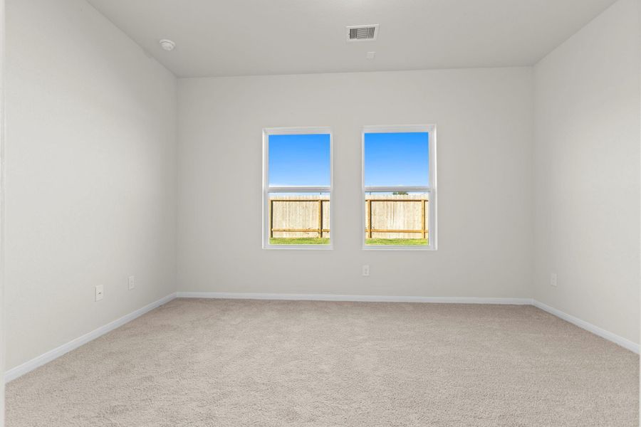 Another view of the inviting primary bedroom highlighting soft carpet flooring, large windows, and natural light that creates a peaceful, welcoming retreat after a long day. All tucked away for your privacy. Another view of the inviting primary bedroom highlighting soft carpet flooring, large windows, and natural light that creates a peaceful, welcoming retreat after a long day. All tucked away for your privacy.