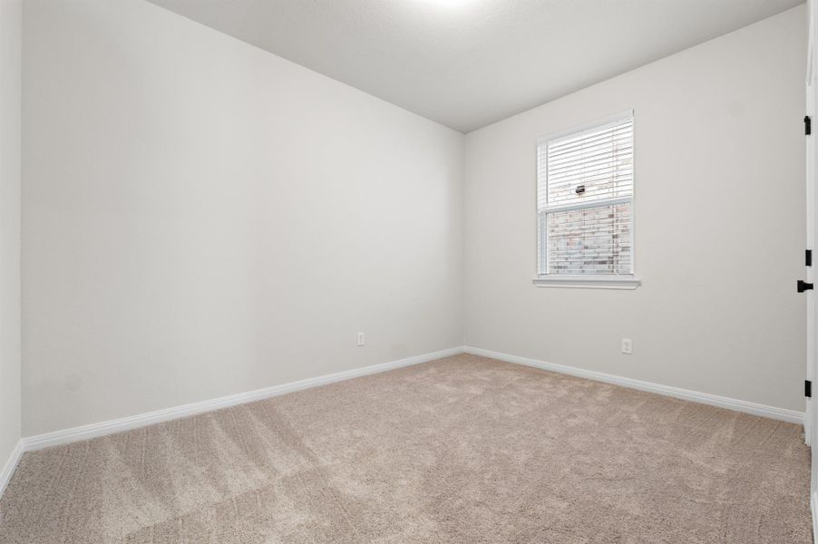 Bedroom with baseboards and light carpet Bedroom with baseboards and light carpet