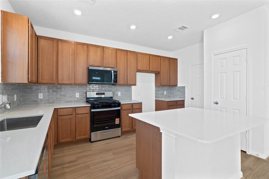 Stainless steel appliances and a large undermount single-bowl kitchen sink with Moen kitchen faucet completes the space, while an added pantry offers more storage. Natural light flows through the windows, enhancing the inviting atmosphere and making this kitchen a true centerpiece of the home. Stainless steel appliances and a large undermount single-bowl kitchen sink with Moen kitchen faucet completes the space, while an added pantry offers more storage. Natural light flows through the windows, enhancing the inviting atmosphere and making this kitchen a true centerpiece of the home.