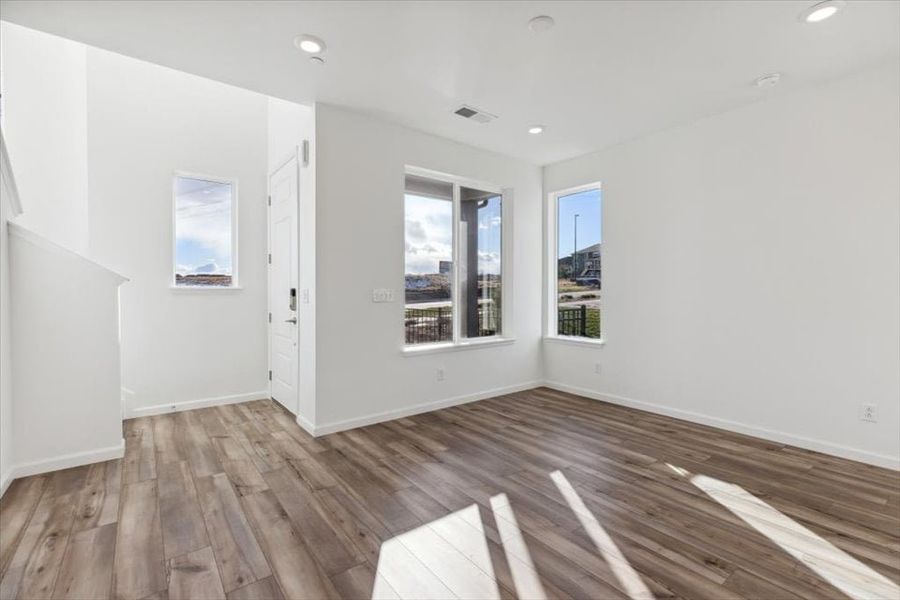 A room with a wood floor and a wood floor with a window.
