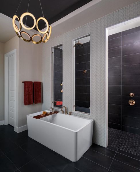 Bathroom with tile patterned flooring, a freestanding bath, wallpapered walls, a tile shower, and a chandelier Bathroom with tile patterned flooring, a freestanding bath, wallpapered walls, a tile shower, and a chandelier