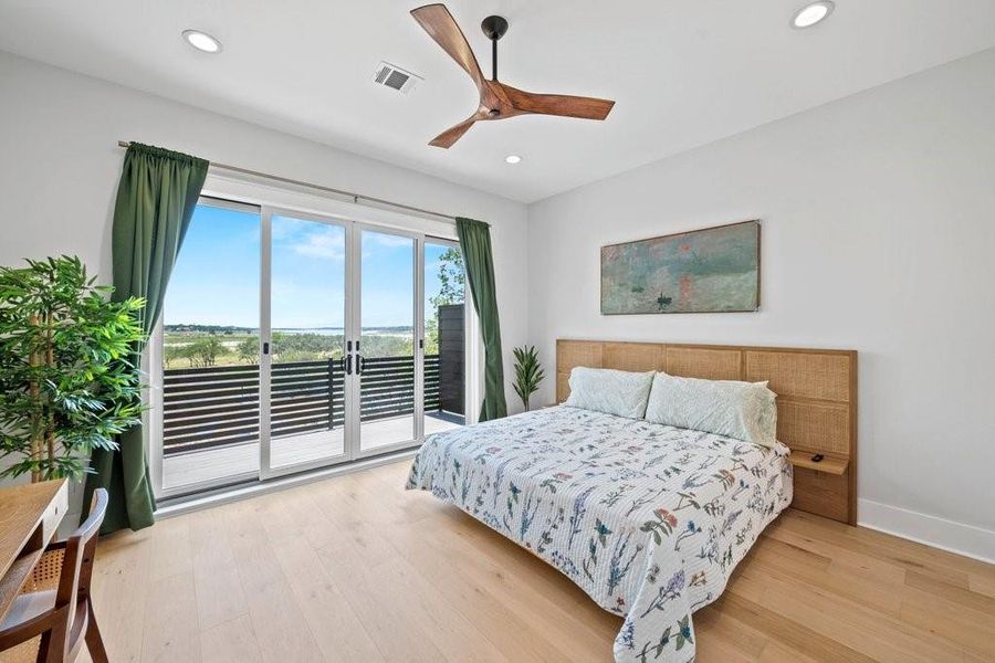 Wake up to sweeping views of Canyon Lake from this tranquil primary suite. Featuring sliding glass doors to a private balcony, warm wood floors, and a minimalist design—this space is your perfect Hill Country retreat.