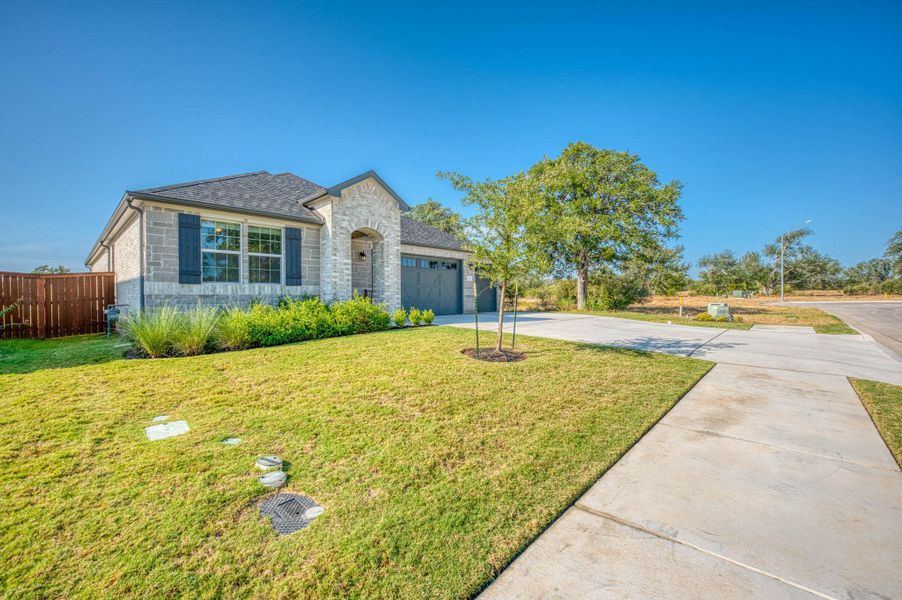 A classic stone facade and wide concrete driveway define this modern single-story residence.