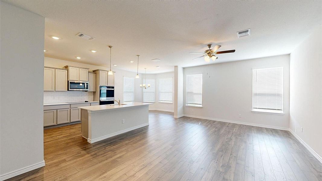 Open concept living area featuring light-colored flooring, recessed lighting, and a ceiling fan