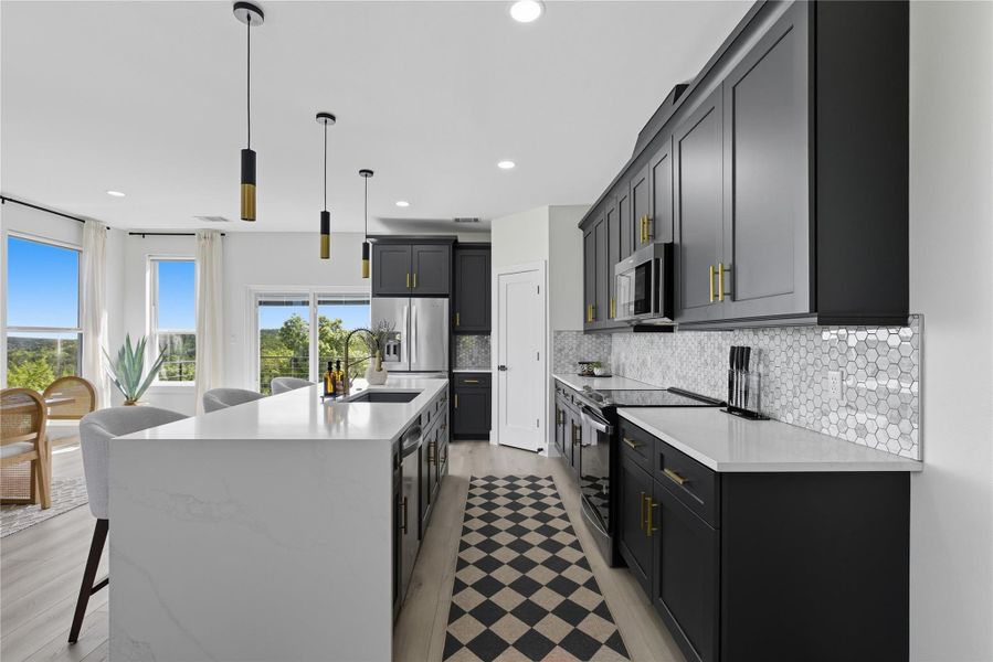 Kitchen featuring light stone counters, stainless steel appliances, decorative light fixtures, a kitchen breakfast bar, and recessed lighting