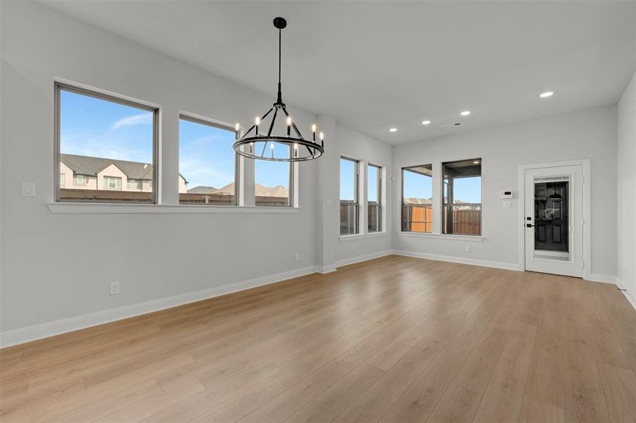 Unfurnished dining area featuring a chandelier and light wood-style flooring