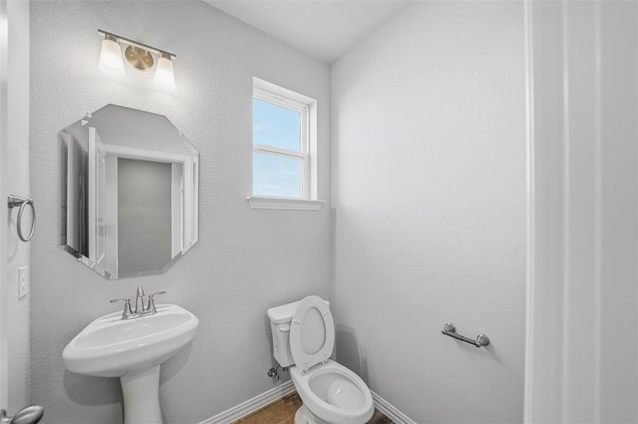 Half bathroom featuring baseboards and toilet Half bathroom featuring baseboards and toilet