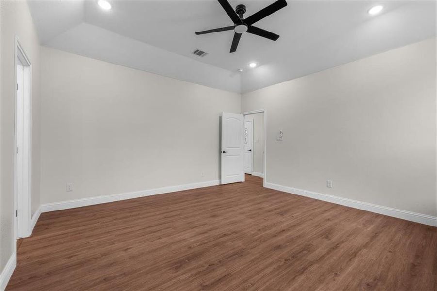 Unfurnished room featuring ceiling fan, lofted ceiling, and dark hardwood / wood-style floors