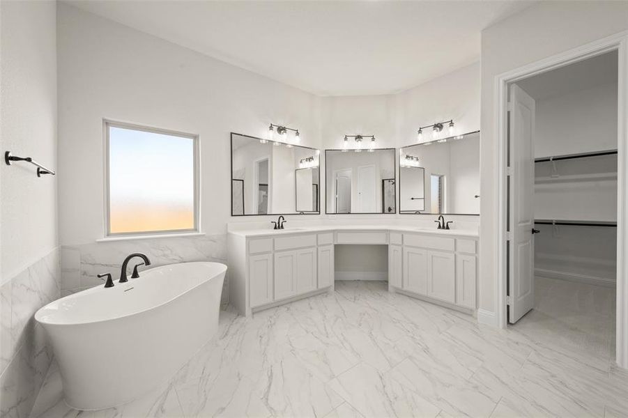 Master bathroom with freestanding tub, dual sinks, makeup vanity, and tile flooring.
