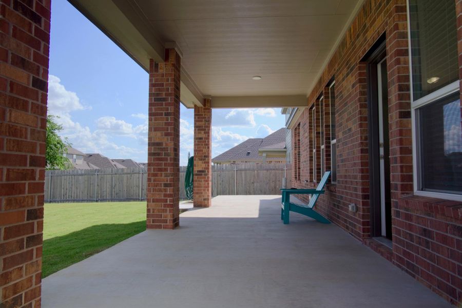 An inviting covered patio with brick columns offers an ideal space for outdoor enjoyment.