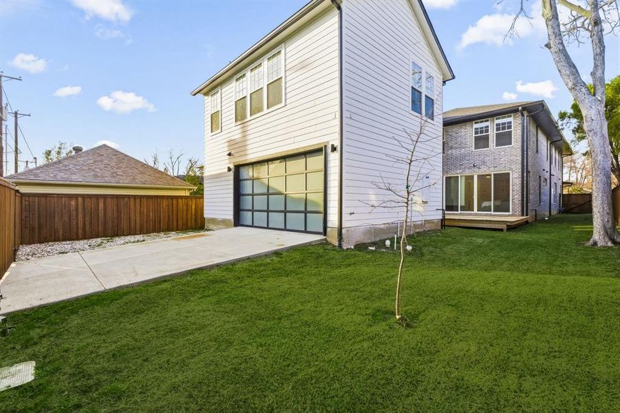 Back of property featuring an attached garage, driveway, and brick siding